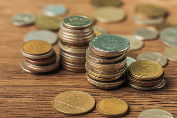 selective focus of coins stacks on wooden and blurred background