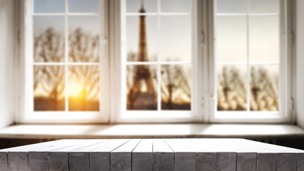 Table background of free space for your decoration. White wooden window space. Sunset time and Paris city landscape. 