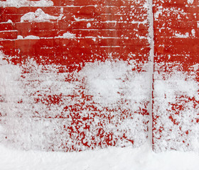 Snow on a red brick wall as background