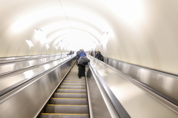 Blurred photo of people on the escalator in the subway