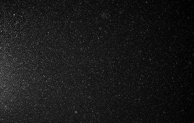 Snow flies in the sky at night as a background