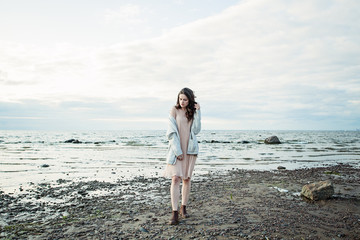 Nice model woman in silky dress against the sky and sea, romantic portrait