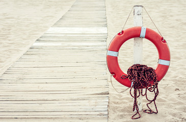 Lifebuoy next to boardwalk on the beach of Catania, Sicily, Italy.
