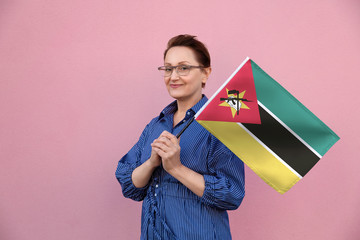 Mozambique flag. Woman holding Mozambique flag. Nice portrait of middle aged lady 40 50 years old...