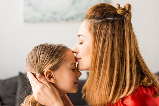 Close up of mother kissing daughter at home