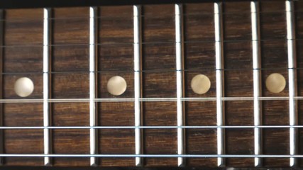 Close up of chords being strummed and vibrating during playing. Trembling guitar strings against fret. Beautiful background with wooden texture. Music performance. Slow motion - Powered by Adobe