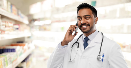 medicine, technology and healthcare concept - smiling indian male doctor or pharmacist in white...