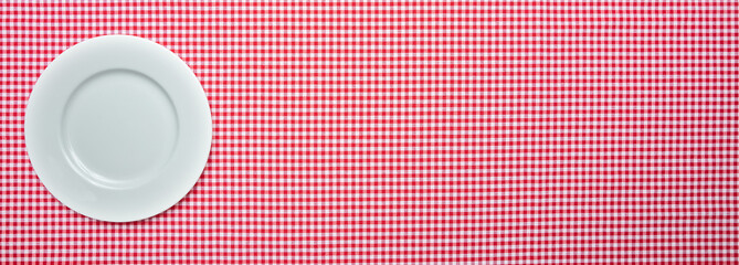 Empty white plate on red checkered tablecloth background, banner