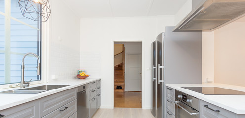 banner of a stylish kitchen interior with open door into the hallway and grey interior