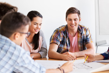 education, architecture and people concept - group of smiling students with blueprint meeting indoors