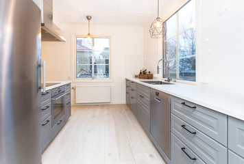 Fototapeta na wymiar strylich kitchen interior with grey interior and windows