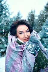 beautiful woman is in winter forest, green fir trees with snow