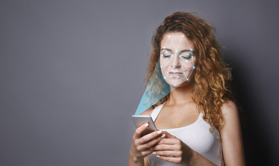 Woman with smartphone using face ID recognition system
