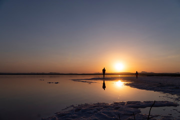 Spacer o zachodzie słońca nad słonym jeziorem Laguna Rosa w Hiszpanii