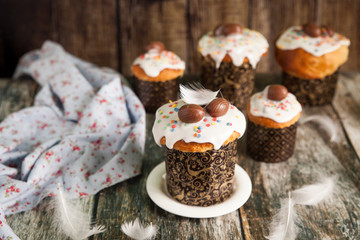 Traditional Easter cake kulich decorated with icing and chocolate eggs