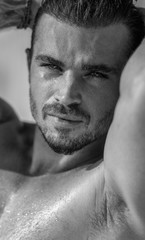 Vertical portrait of a handsome caucasian male model posing on the beach