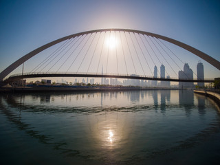 Naklejka na ściany i meble Panorama of the city early in the morning at dawn with a bridge over the city channel Dubai Greek.