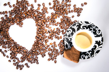 Heart make whit coffee beans and cup whit espresso and sweet heart cookie on wood table background. 