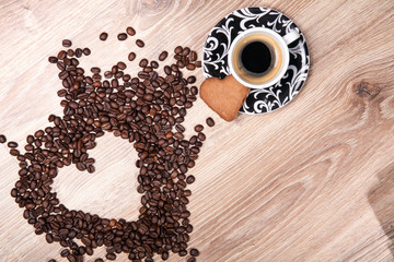 Heart make whit coffee beans and cup whit espresso and sweet heart cookie on wood table background. 
