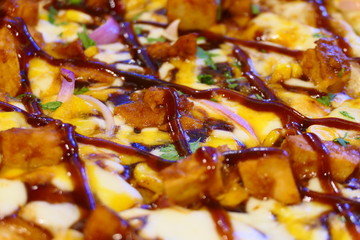 Close up view on a tasty BBQ Pizza with meat, cheese, corn, onions and ketchup sauce