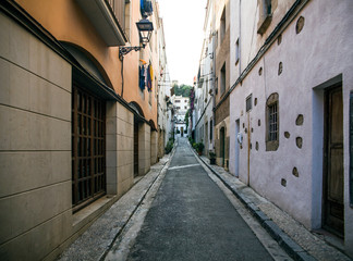 Streets and buildings in the city of Tossa de Mar, Spain. Narrow passages between houses. Shops and restaurants in the center.