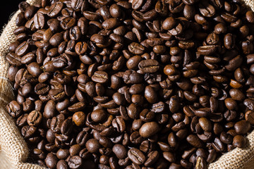 Close up coffee beans in a burlap hessian brown sack. 