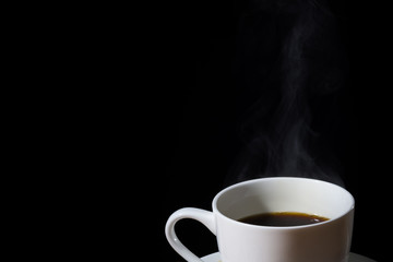 White cup of brewed coffee with steam or vapor and isolated in black. 