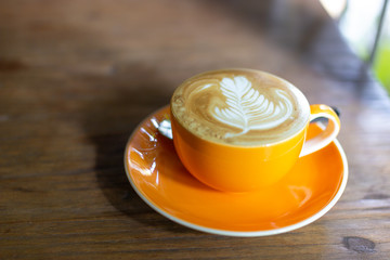 hot milk coffee with late art on top isolate on wooden table