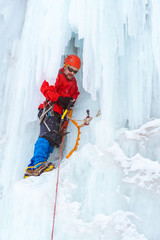 ice climber on the vertical wall of the glacier