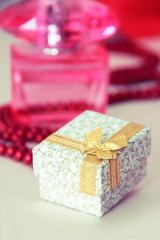 gift in a decorative white box with a gold bow for the holiday of March 8 or Valentine's Day