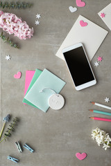 Springtime flat lay with pearl hyacinth flowers, eucalyptus, mobile phone and gift postcards