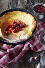 American cuisine: Duth beby lush omelet, powdered sugar and cherry jam dressing