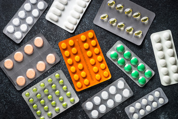 Pills blister colored Tablets and on black  top view.
