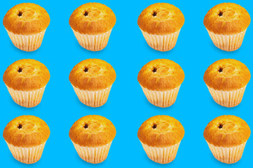 Horizontal rows of baked muffins without cream in paper form on blue background. Seamless pattern