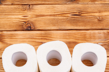 Toilet paper rolls on wooden background top view