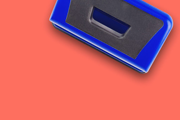 One blue metallic hole puncher on office table or school desk living coral color. Copy space for your text. Top view. Business or education concept