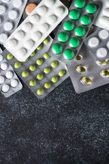 Pills blister colored Tablets and on black  top view.