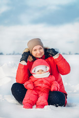 Mom and daughter pose for a winter photo shoot in snowy winter