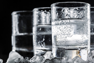 Vodka in shot glasses on rustic wood background