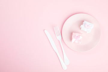 Festive table setting for Valentines Day with fork, knife and hearts  on pink pastel background.Romantic dinner. Space for text. Top view.