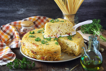Spaghetti pie with lard and cheese, parsley dressing