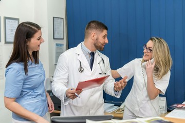 Fototapeta premium Male doctor and two female nurses inside a hospital, concept