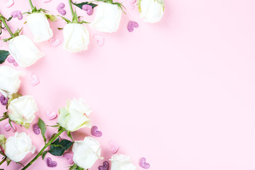 Valentines Day composition. White rose flowers on pastel pink background. Confetti heart shaped. Mothes day, Womens Day Holiday concept. Flat lay, top view, copy space.