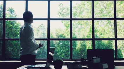 Business executives stood looking out the window to find inspiration. Or the idea to make his...
