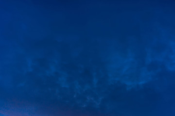 Amazing dramatic blue cloudy sky nightly. Atmospheric minimalist natural background of night in overcast weather. Hard cloudiness. Storm clouds warning. Beautiful dark cloudscape. Darkness. Copy space