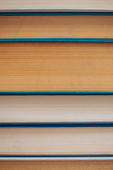 Vintage books close-up. Stack of used old literature in school library. Background from old chaotic reading matter. Dusty faded books horizontally with copy space. Old book store.