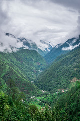 Fototapeta na wymiar Tropical mountain range view. Timelapse Of Moving Clouds And Fog over Himalayan mountain range in Sainj