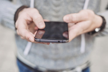 Men using smartphone outdoors. Male hands texting on mobile phone