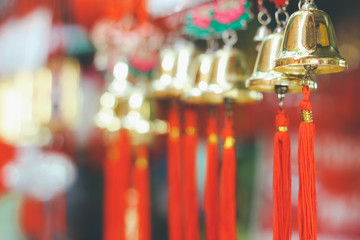 Closeup view of many beautiful old fashioned golden christmas bells hanging as new year toys, horizontal picture blurred