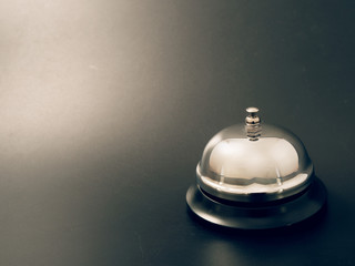 bell at the reception desk made of metal on a black background.